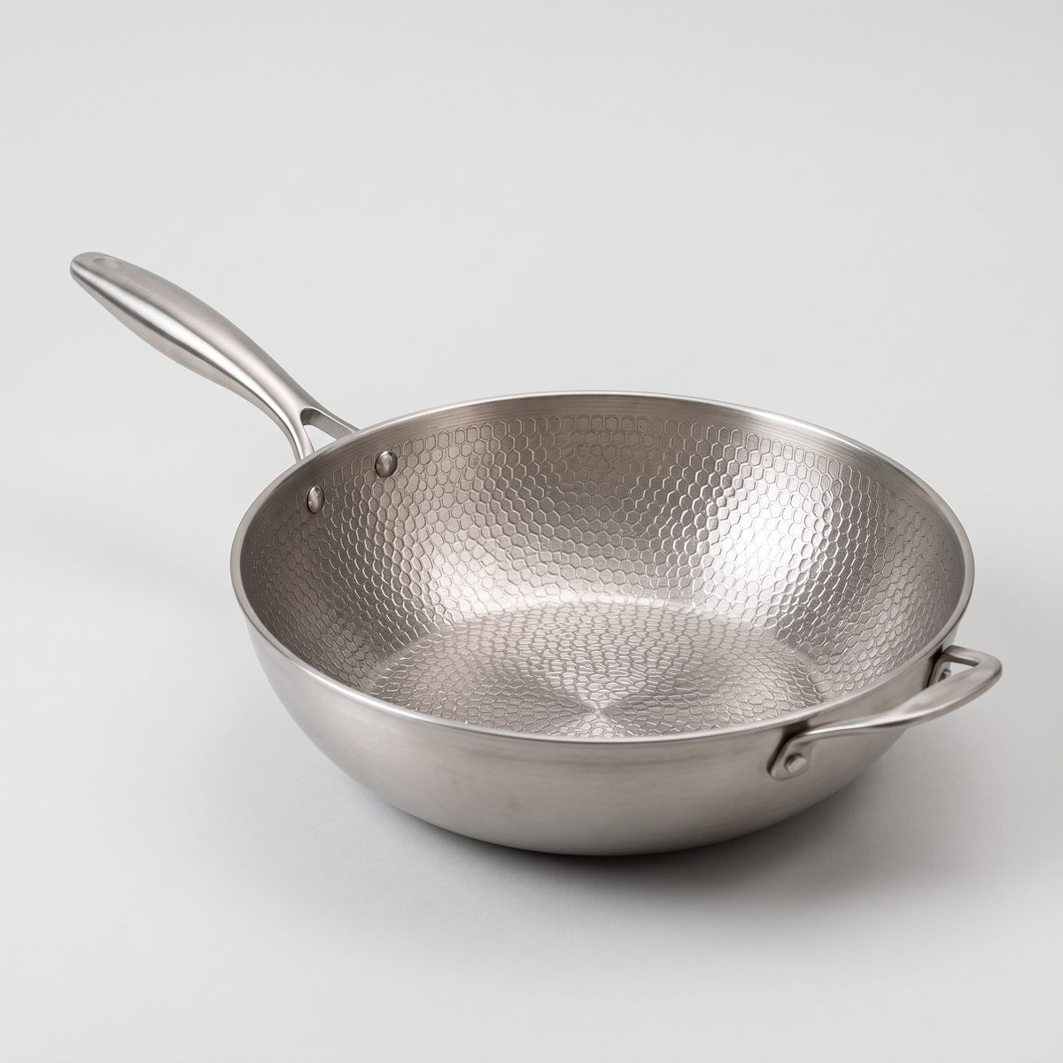 Wok en titane bombé sans revêtement posé sur une plaque de cuisson