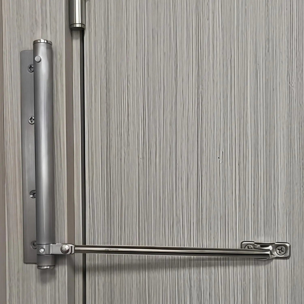 Ferme-porte automatique en acier inoxydable fixé sur une porte